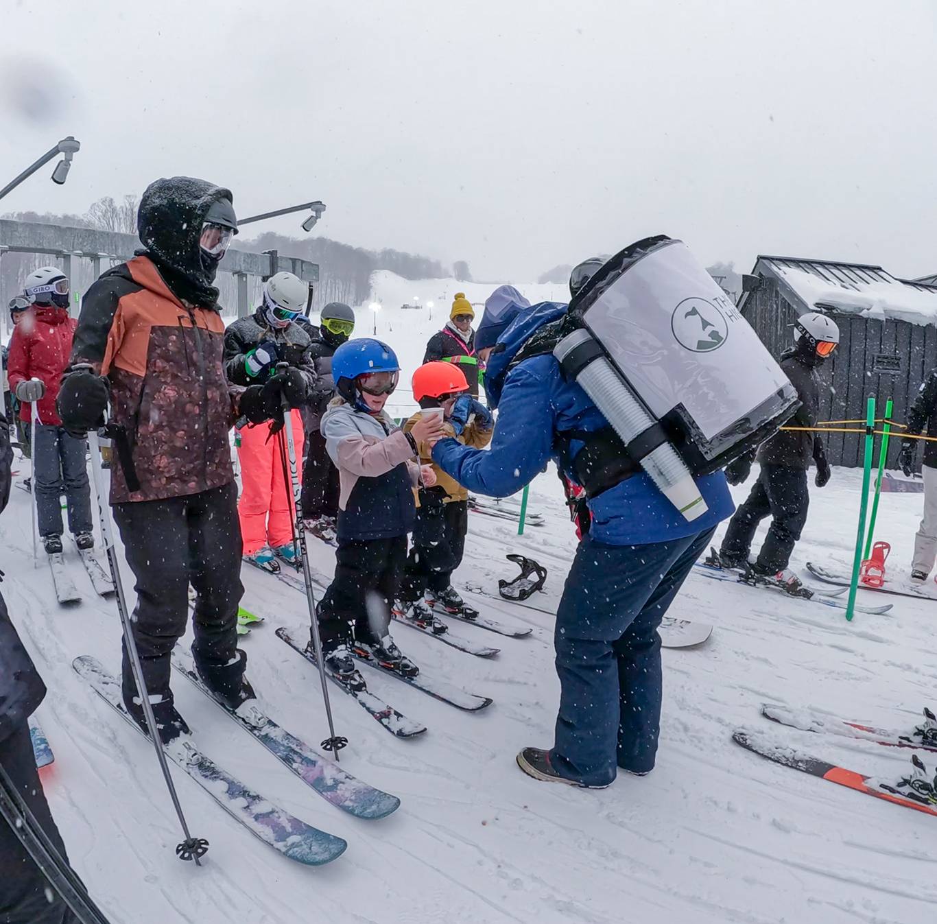 A team member giving hot cocoa in the lift line at The Highlands