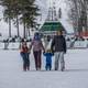 A family walking away from the Heather chairlift in ski gear at The Highlands