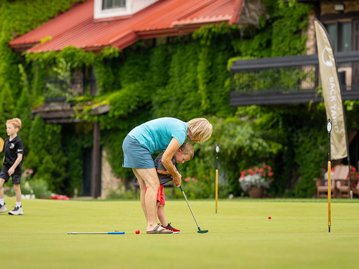 A family putting on the Back Yaird Putting Green