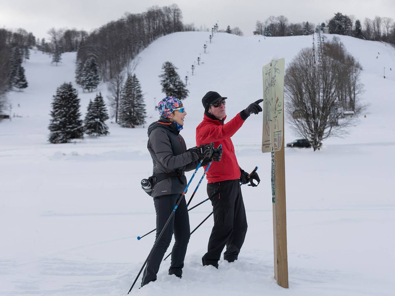 A couple looking at the Nordic Trail Map at The Highlands
