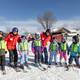 A group of snowsports instructors and kids posing