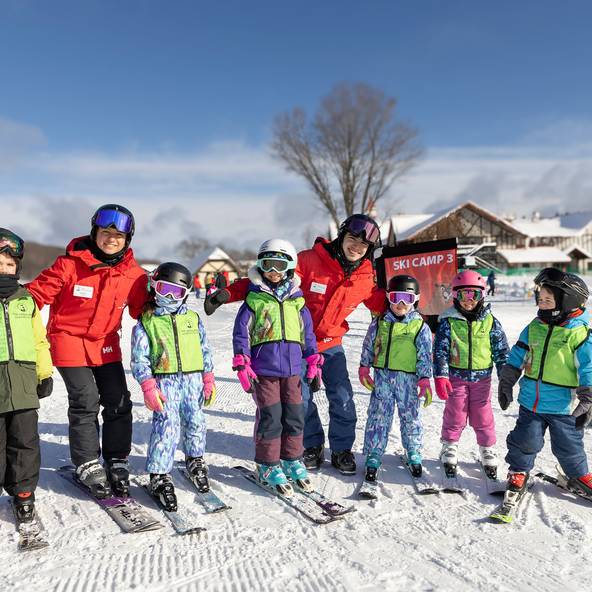 A group of snowsports instructors and kids posing